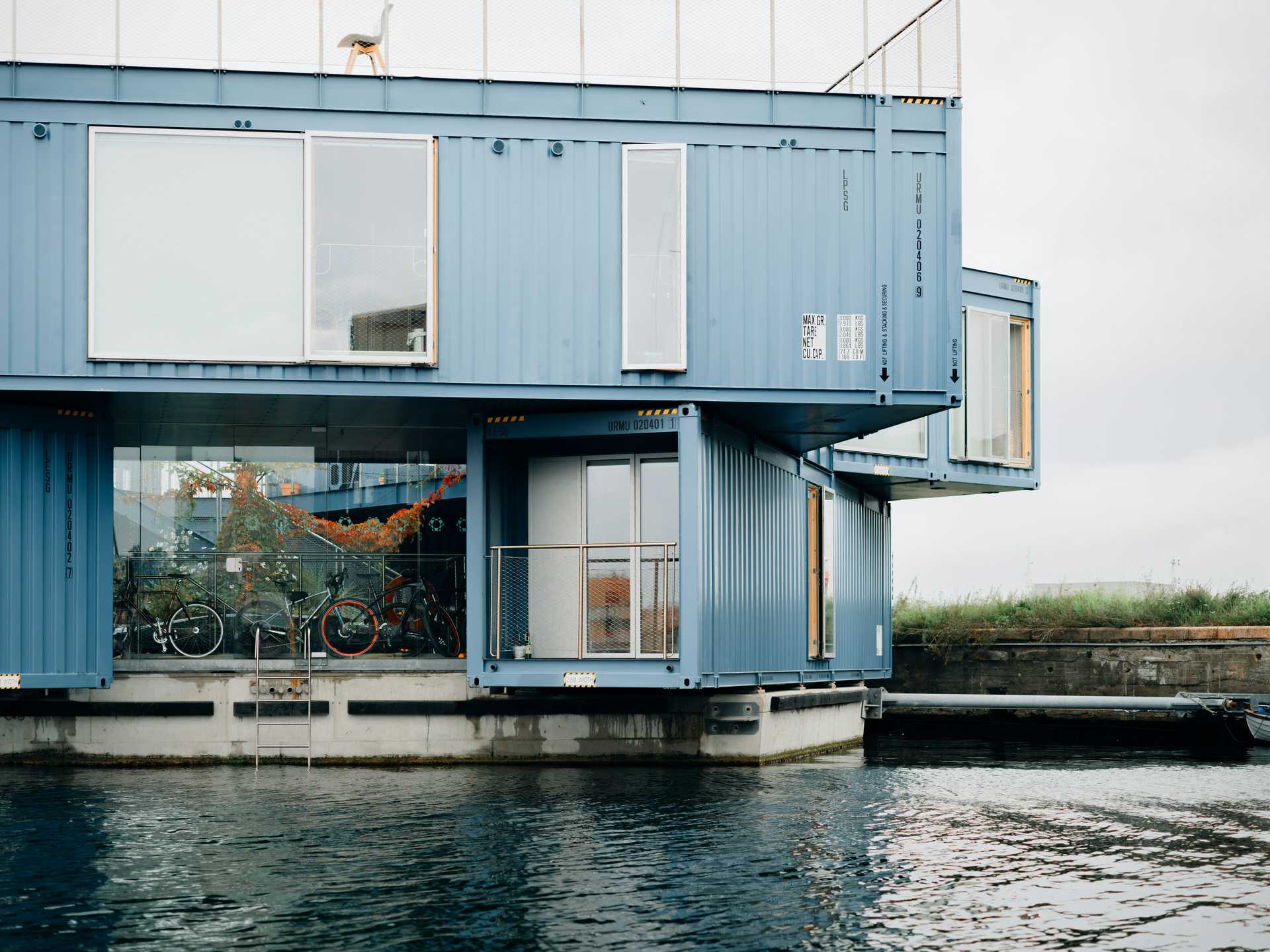 Blue building floating on a body of water.